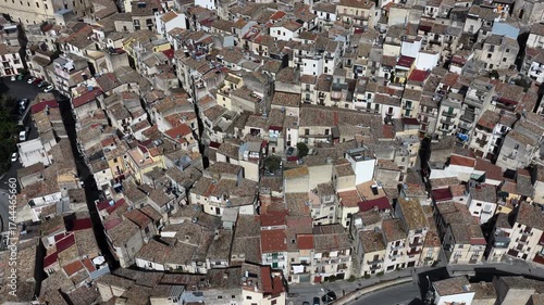 Aerial drone view of Polizzi Generosa, a picturesque Sicilian mountain town perched on rocky cliffs showcasing traditional stone buildings and panoramic views of the Madonie Mountains, Sicily, Italy