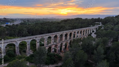 Aerial drone video of The Ferreres Aqueduct (Pont del Diable), an ancient Roman aqueduct near the city of Tarragona in Catalonia, Spain at sunset