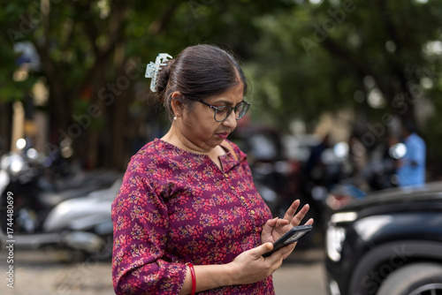 Indian woman speaking in a smartphone anxiously in the street  