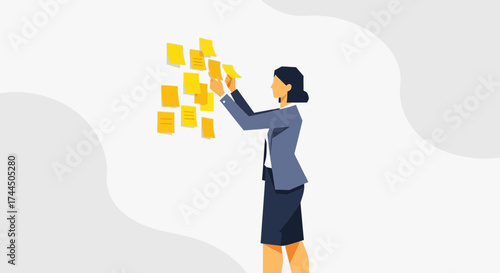 Businesswoman organizing notes on wall: Project management and collaborative planning