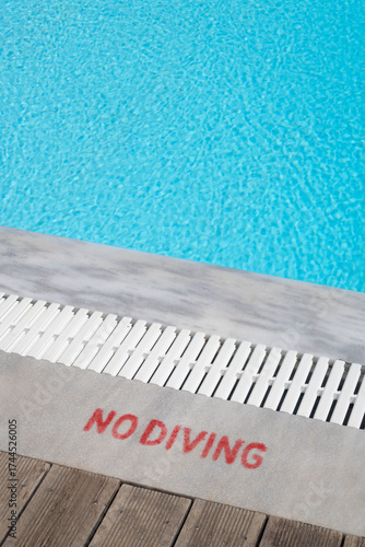 Turquoise swimming pool edge and no diving sign