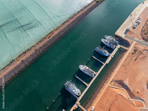 Boats moored at a jetty in a coastal marina channel