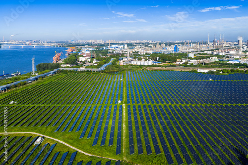 Aerial view of solar panel field with chemical industrial park