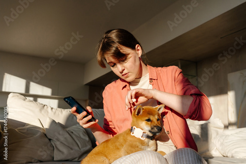 Woman checking GPS tracker on puppy collar