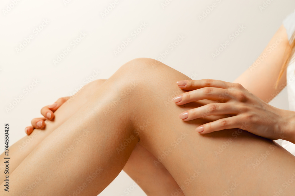 Fototapeta premium woman applying cream on her legs