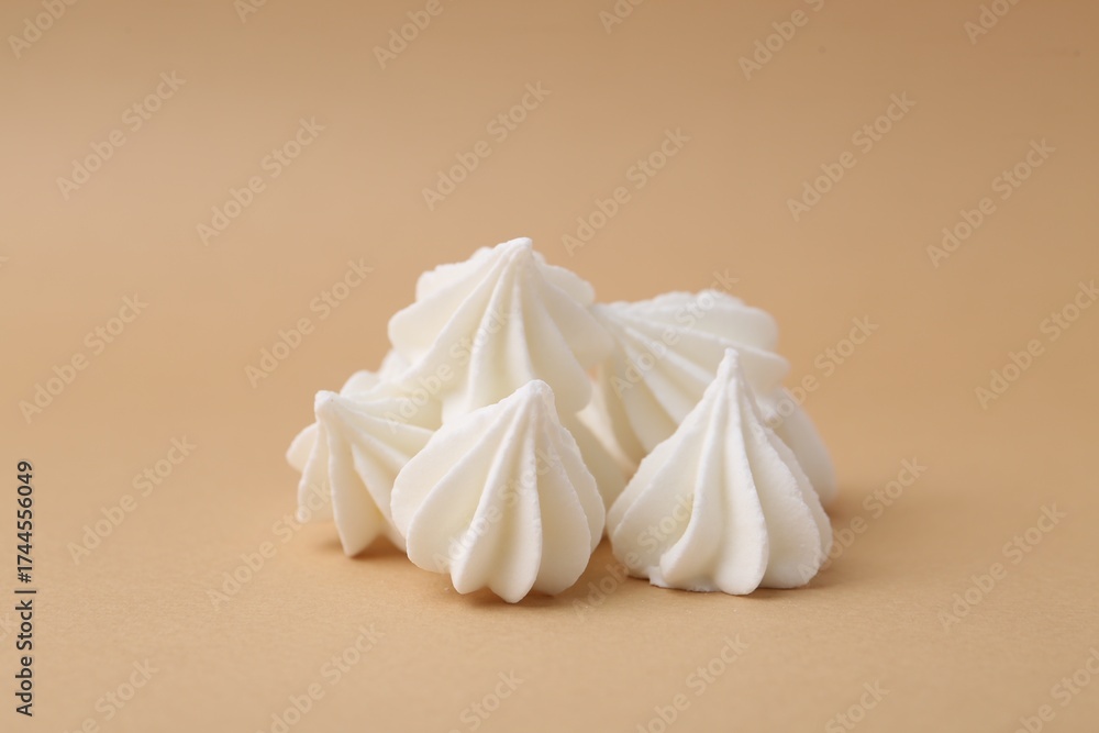 Obraz premium Delicious meringue cookies on beige background, closeup