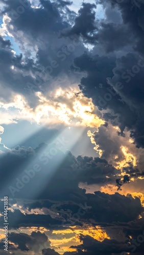 Dramatic image of sun rays bursting through dark clouds