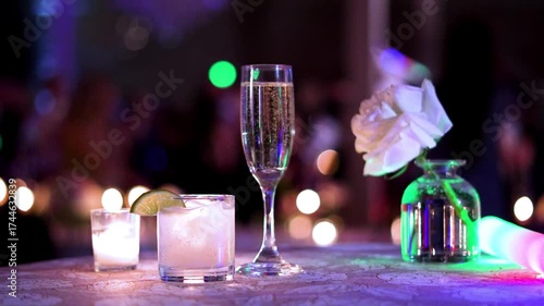 slow motion of drinks on a table during a party wedding reception with people dancing in the background 