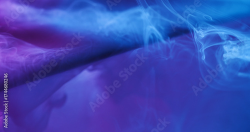 Paint mist. Neon water splash. Defocused blue purple color liquid glass texture spill on abstract acrylic light creative background.