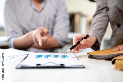 Wallpaper Mural Close up businesswoman holding pen on clipboard talking with man coworker at working table in office Torontodigital.ca