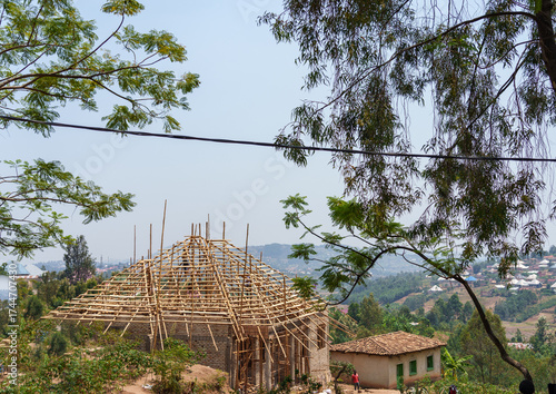 Timber roof framing for a house under construction in African village