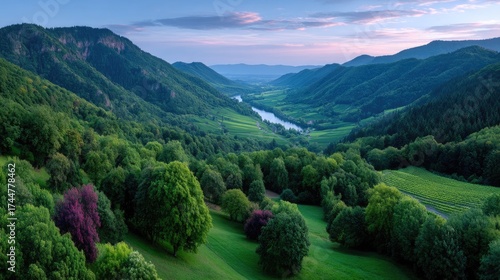 Sunset Over Green Vineyard Hills and Winding River Under Cloudy Sky Panoramic Landscape