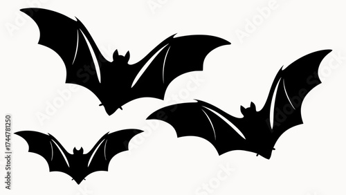 Three black bats silhouetted against a white background with wings spread in a spooky halloween theme