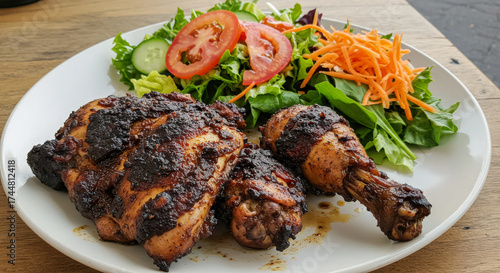 Close-up of flavorful jerk chicken served with a fresh salad. Concept of Caribbean and Jamaican cuisine.