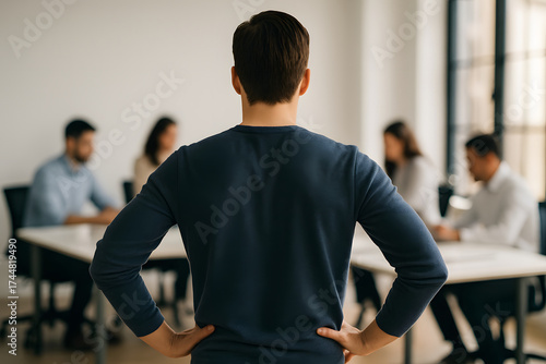 Successful businessman standing with his back to the office, arms crossed
