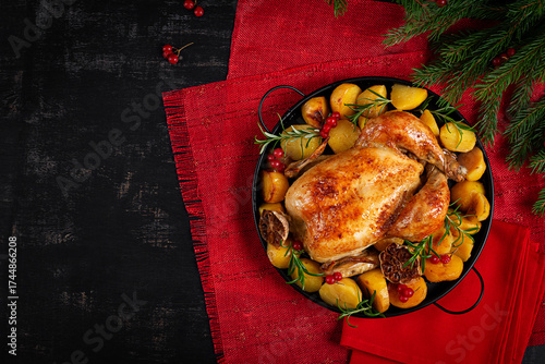 Roasted chicken with potatoes and Christmas decoration. Baked chicken or turkey. Table setting. Top view, flat lay