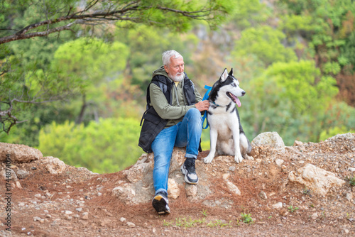 Companionship. senior man relaxing with husky dog in nature forest scene senior man enjoying time outdoors with husky dog symbol of loyalty friendship and bond