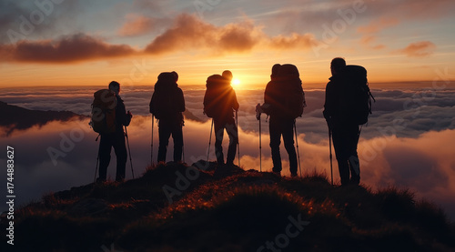 Gruppe von Wanderern auf Berggipfel bei Sonnenaufgang über den Wolken