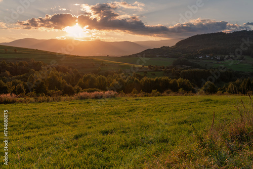 Fototapeta Naklejka Na Ścianę i Meble -  Piękny zachód słońca nad Beskidami, z ciepłym światłem oświetlającym wzgórza i doliny. 