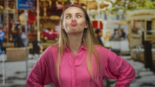 Wallpaper Mural Woman in pink shirt making funny face at outdoor fair surrounded by blurred carousel in background on a sunny day. Torontodigital.ca