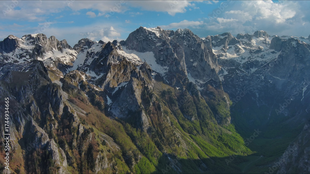 Fototapeta premium Rocky snow mountains before sunset aerial