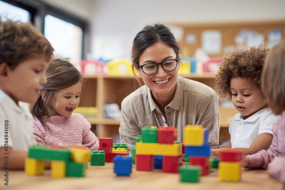Fototapeta premium A teacher is playing with blocks with children in a classroom