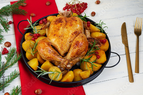 Baked whole chicken. Roasted chicken with potatoes. Winter decoration Christmas chicken