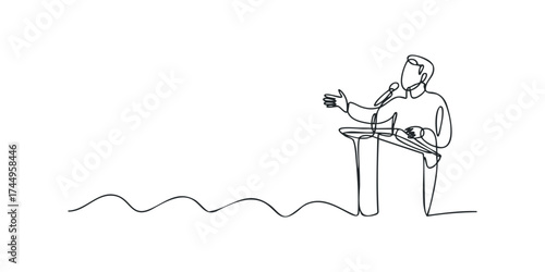 Speaker gesturing at podium with microphone and notes