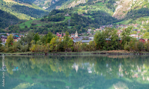 view on alpine french town of Bourg Saint Maurice with reflection on blue water  of  a lake in french alps