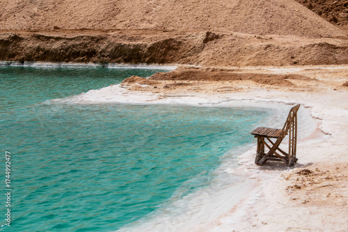 empty wooden chair at beautiful blue salt lake in Siwa oasis, Egypt
