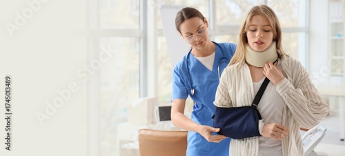 Injured young woman with broken arm after accident visiting doctor in clinic....