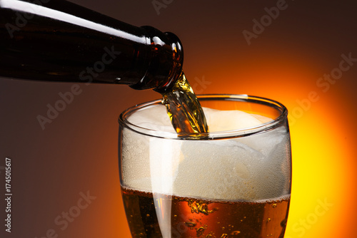 Beer with Froth Pouring from Bottle to Glass