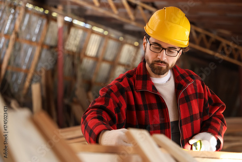 Male carpenter measuring wo...