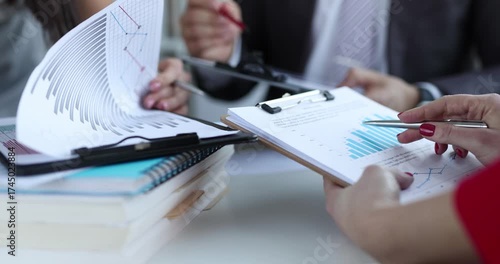 Marketing team analyzes commercial data with charts in board room at meeting. Colleagues plan future activities of business company in office