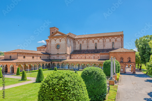 Saint Christopher Church in Charterhouse of Ferrara features a stunning Renaissance porch with elegant arches and columns, alongside a tall bell tower under a clear blue sky in Ferrara city of Italy