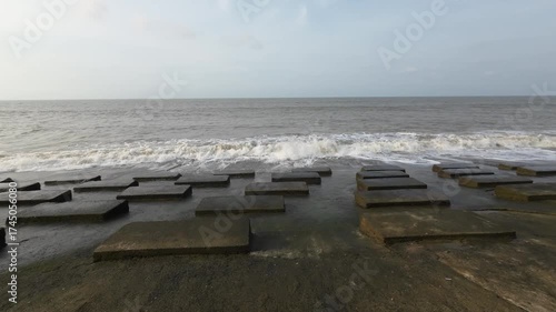 Concrete Blocks on Coastal Shoreline with Ocean Waves Crashing at High Tide