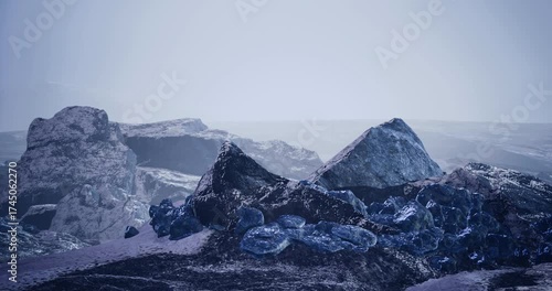 Wallpaper Mural An expansive rocky terrain features large stones and shimmering blue crystals. The distant hills blend into the misty horizon under a soft gray sky, suggesting a cool atmosphere. Torontodigital.ca
