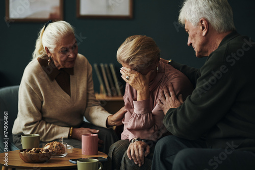 Εκτύπωση καμβά Three senior Caucasian people comforting each other, two women and one man sitti