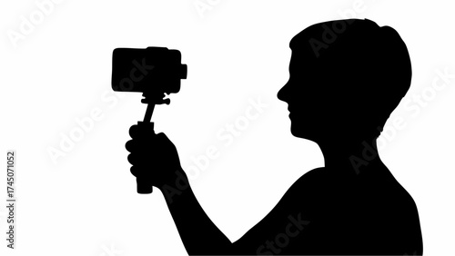 Silhouette of a person holding a smartphone on a selfie stick against a white background in a studio shot