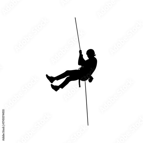 Silhouette of a person rappelling down a rope, adventure sport.