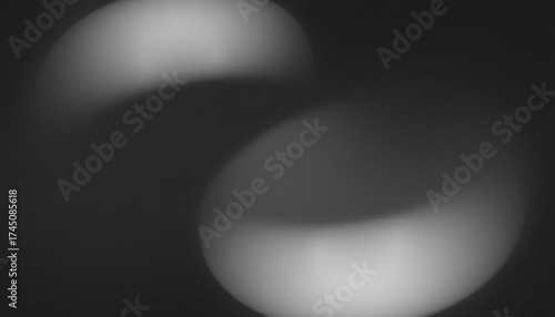 Abstract monochrome image featuring two blurred circular shapes against a dark background space