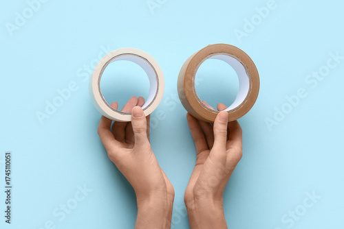 Hands holding two rolls of ...
