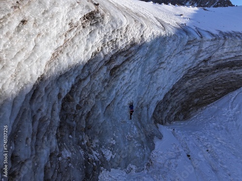 Ice climber scaling a glacier wall in mountains, bogdanovich glacier, Kazakhstan
