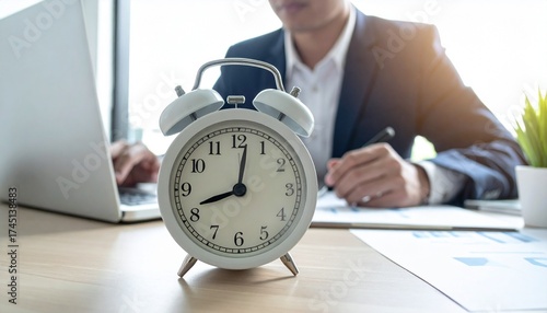 Alarm Clock on Desk with Business Man Working, Time Management Concept