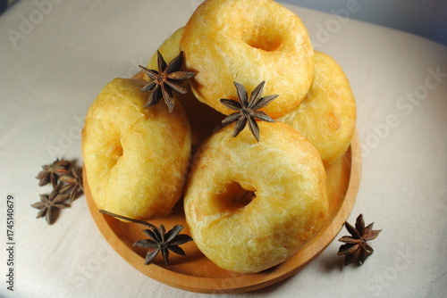 Konstfotografi Golden brown homemade donuts served on a wooden plate