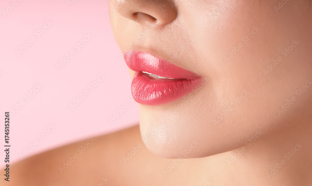 Obraz premium Woman with beautiful lipstick on her lips against pink background, macro view