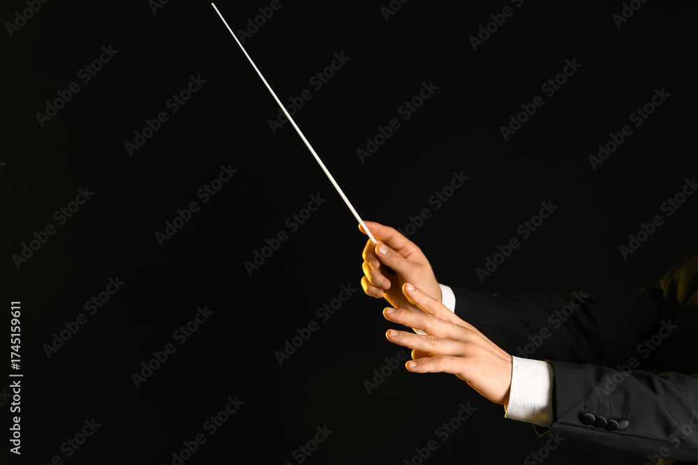 Fototapeta premium Hands of male conductor with baton on black background
