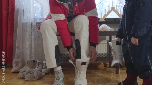 Grandmother dressing child in warm winter clothes indoors in Finland, cozy Nordic family lifestyle with seasonal clothing and care.