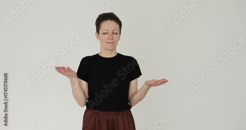 Lady presenter raises palms at shoulder height showing balance idea. Speaker moves hands side to side weighting options like simple scale slow motion