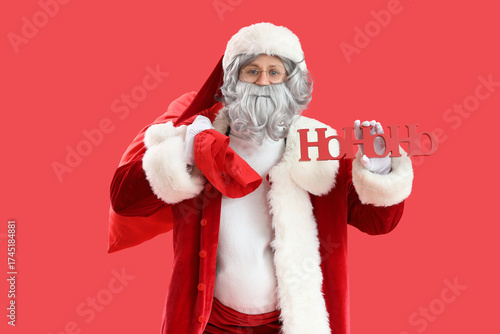 Santa Claus with bag full of gifts and HOHOHO word on red background